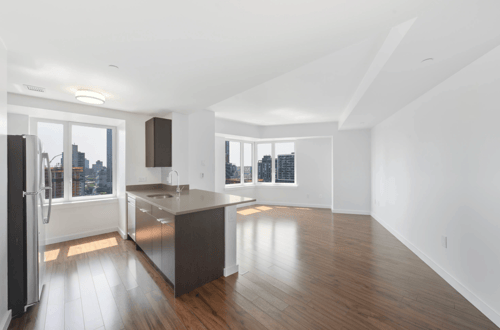 A modern kitchen with a wooden floor and a large island. at 7 Dekalb, Brooklyn, 11201
