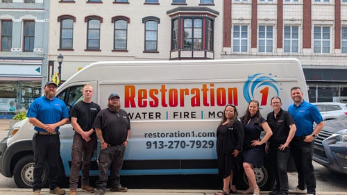 The Entire team for Restoration 1 of Leavenworth is shown standing next to their work van in Downtown Leavenworth. 
Pictured (Left to Right): Nick Coggin, Cam Wilkins, Vinny Duarte, Yvonne DeJarnatt, Jo Anna Feagans, Rachael Rice, Nicholas Feagans.