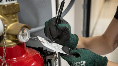 Person performing a check on fire suppression system