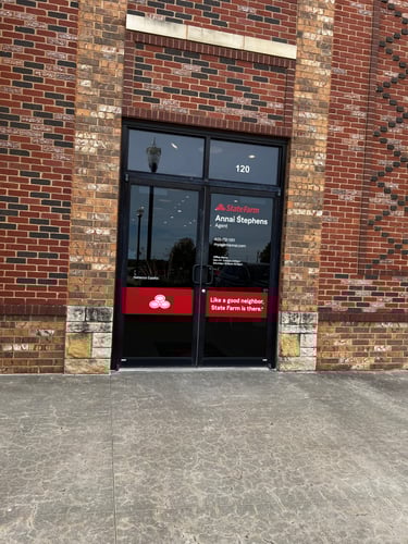 Brick building with red State Farm logo on black front door