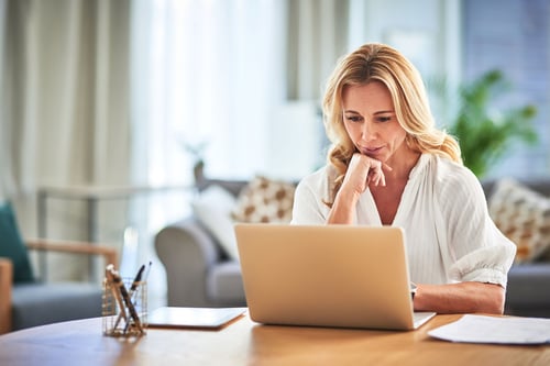 Woman sitting at table looking at computer