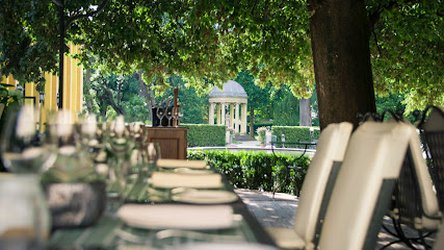 Restaurant's tables in the shade of trees with the view of the city.