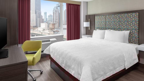 Landscape photo of the standard King size room with a city view featuring desk and flatscreen TV.