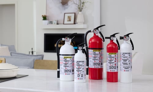 A group of Kidde Fire Extinguishers sit on a kitchen counter.