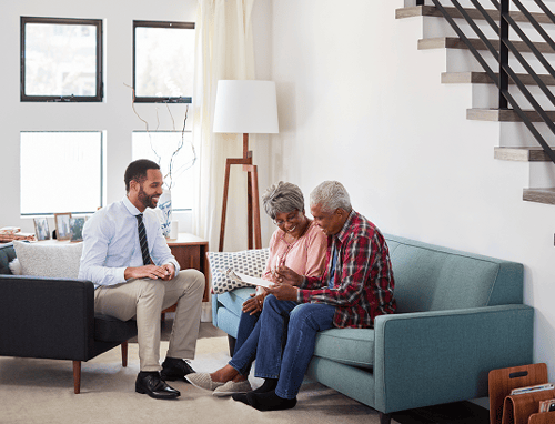 A senior couple meeting with an advisor in their living room.