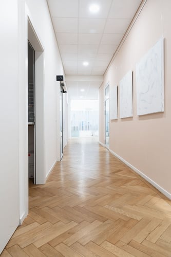 Couloir moderne d’Ardentis Cliniques Dentaires et d'Orthodontie La Tour-de-Peilz reliant les espaces de soins dentaires et d’orthodontie dans un environnement lumineux, contemporain et pensé pour le confort des patients.