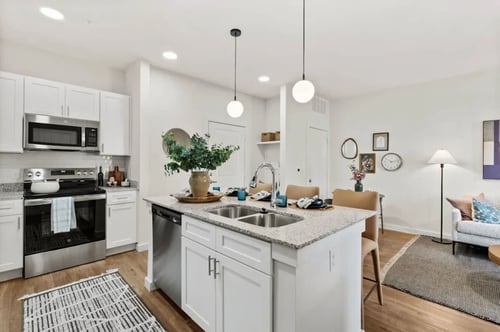 A modern kitchen with white cabinets and stainless steel appliances at Hudson at Pecan Creek Apartments, Denton, TX, 76205