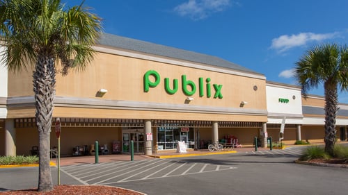 Palm trees on either side of the front entrance of Publix on a sunny day