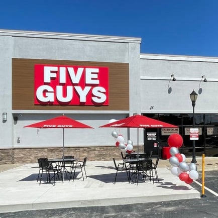 Exterior photograph of the entrance to the Five Guys restaurant at 309 Huffman Mill Road in Burlington North Carolina.