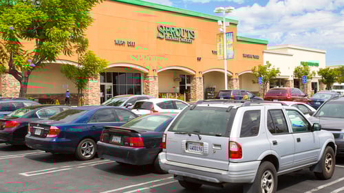 Full parking lot with a tree on the left in Sprouts at Upland Town Square