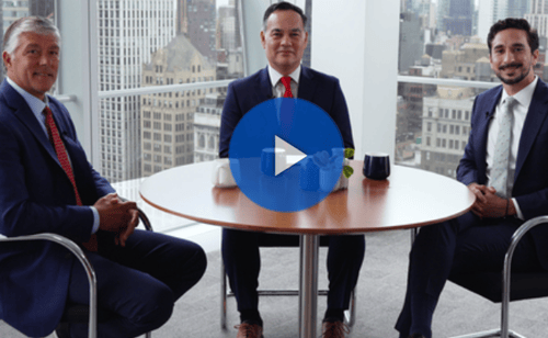 Three men sitting around a table