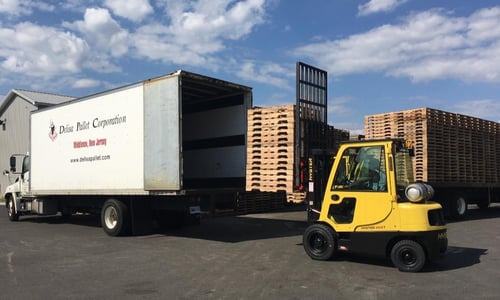 Delisa Pallet delivery truck being loaded with pallets from a forklift