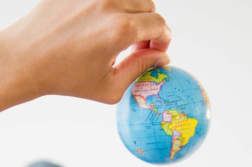 Globe de tenue de main représentant des expéditions caritatives et un impact sur la communauté mondiale