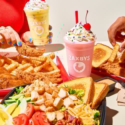 Plates of fingers, wings, zalads, and milkshakes.
