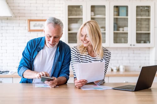 a couple at the kitchen table working on their wealth plan.