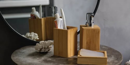 Bathroom accessories including a soap dispenser, toothbrush holder and soap dish on a modern bathroom countertop