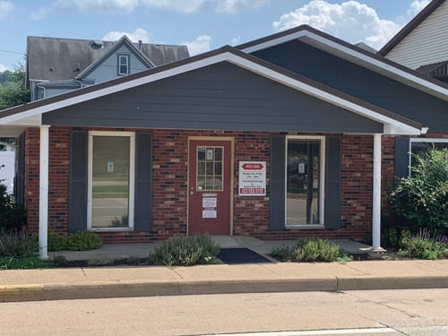 Blue building with brick siding and red and white State Farm sign