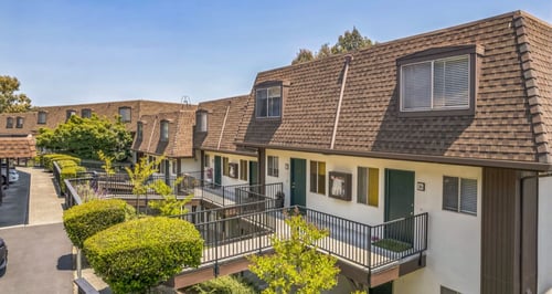 A row of houses with balconies and greenery at Posada East