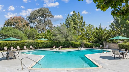 A swimming pool surrounded by trees and chairs.at Posada West, Novato, CA 94949