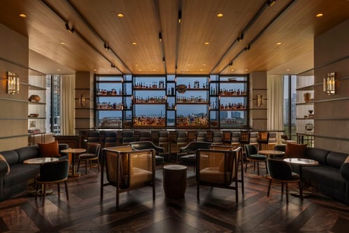 Upscale bar and lounge at Tesserae with stools, a fully stocked bar, and warm ambient lighting.