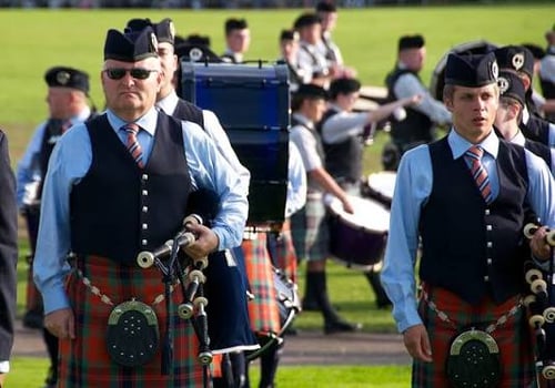 bagpipers on grass preparing to play