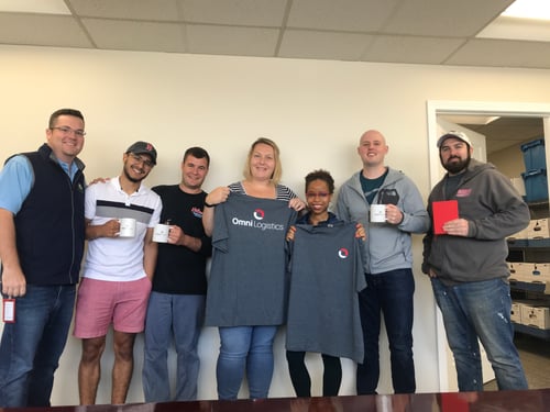 Omni Logistics Billerica team members smile with Omni Logistics office supplies in the office