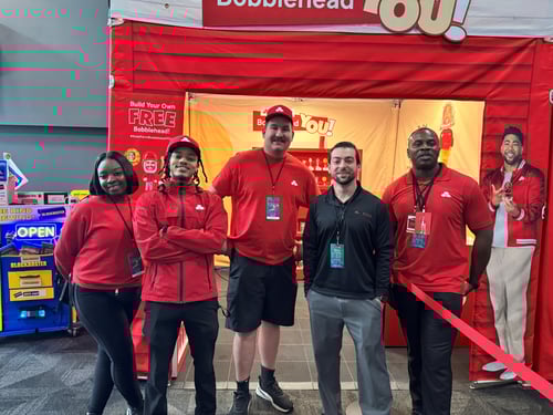 4 people wearing red standing in front of a red tent