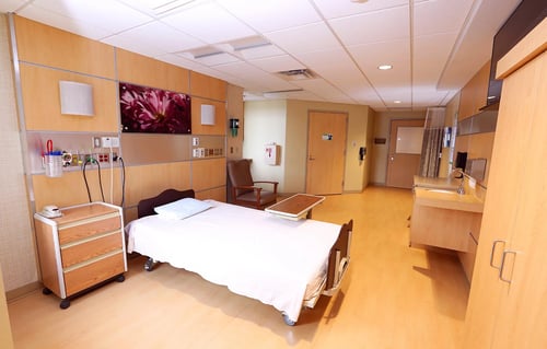 A view of the labor and delivery room showing a bed, sink and chair.