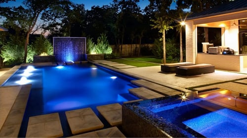 Custom pool and spa lit up at night time