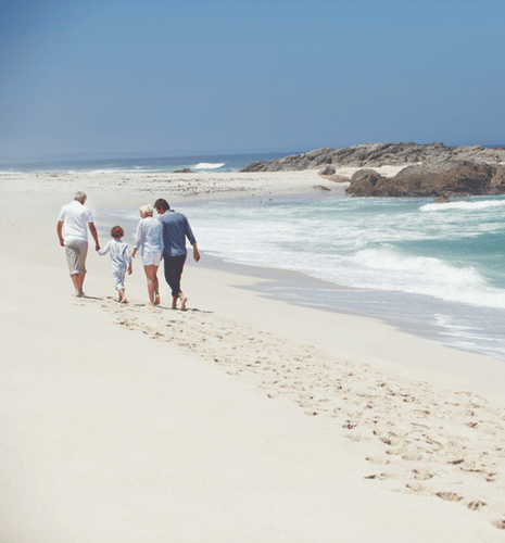 A family walking on a sandy beach.