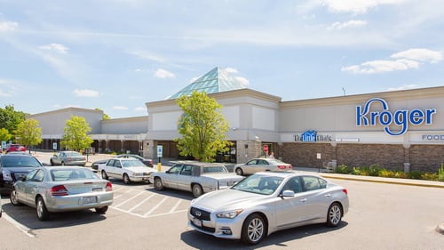 Multiple white cars in parking lot of Kroger entrance