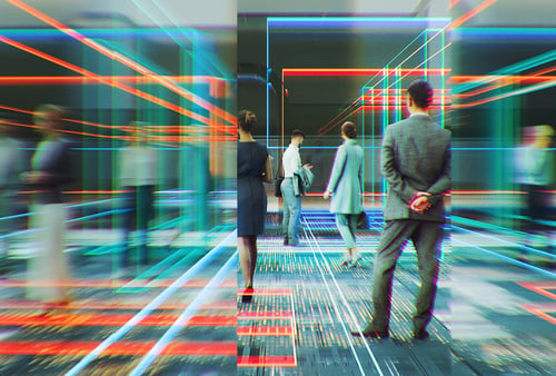 Business professionals interact in a digital environment with neon lines and data visualizations overlaid on a modern office space.