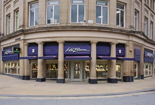 The shop front of H L Brown Sheffield with purple signs and shop windows.