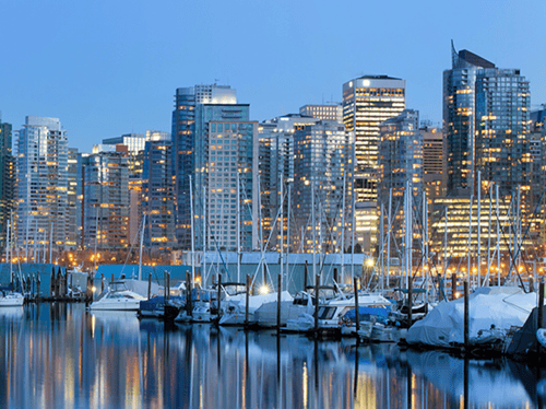 A city and boats at night reflecting off the water