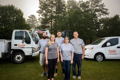 A group photo of the Premier Gasworks team standing in front of their company truck and van
