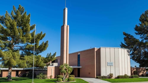 Mid-Century-Modern light brick church building with tall, stand-alone spire