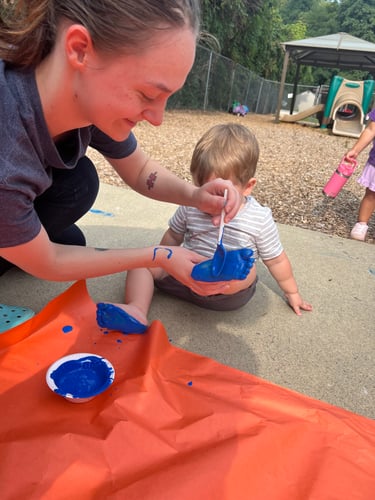 Child’s feet covered in paint, creating a colorful footprint artwork.