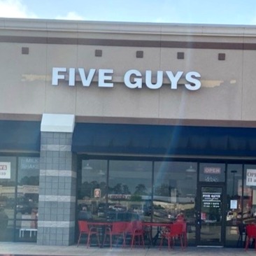 Exterior photograph of the Five Guys restaurant at 507 I-45 in Conroe Texas.