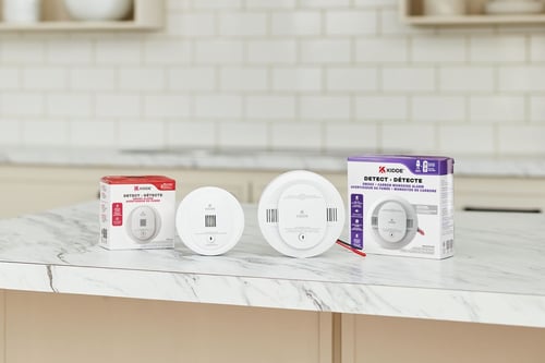 Deux nouveaux produits Kidde Detect sont posés sur un comptoir à côté des emballages dans lesquels ils sont arrivés.