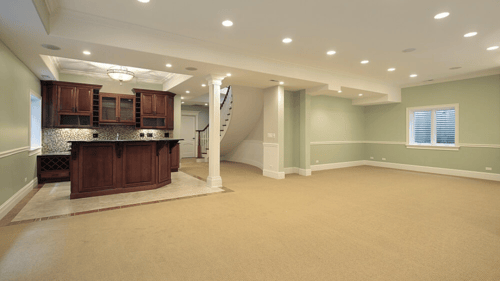 large remodeled basement with carpet and a large bar area
