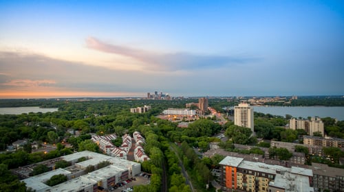 Suburban neighborhood at dusk with city skyline in the distance at The Original at West Lake Quarter Apartments in Minneapolis, MN