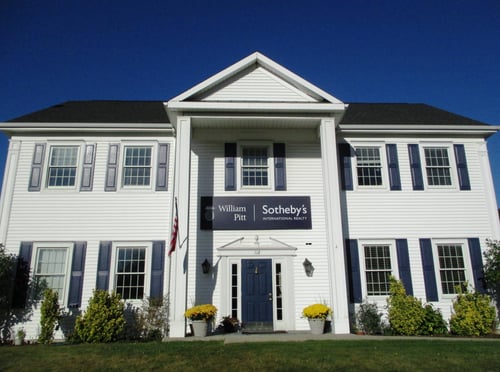White colonial-style building with blue shutters and a pediment entrance housing William Pitt Sotheby's International Realty in Danbury, Connecticut.