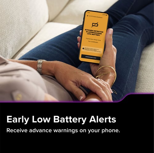 A person holds their phone, the text below reads "Early Low Battery Alerts. Receive advanced warnings on your phone."