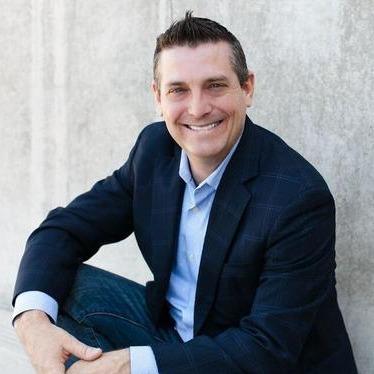 Male agent Craig Pretzinger  in front of a grey background