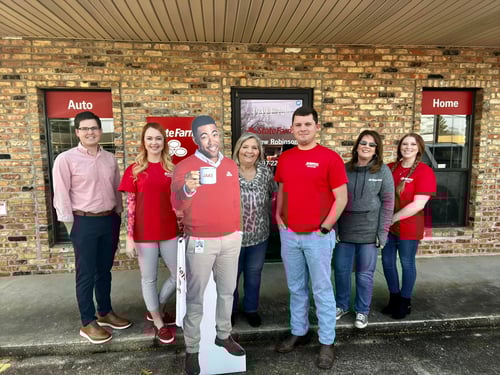 Andrew and team members standing and smiling together outside of office