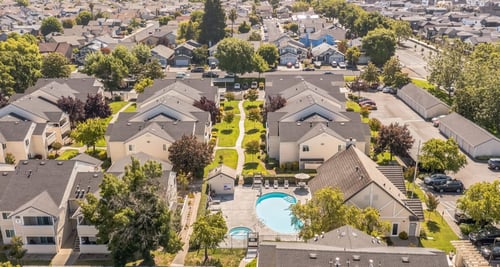 A bird's eye view of a residential area with houses and a swimming pool at Emerald Pointe