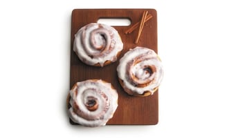 3 cinnamon rolls on a cutting board
