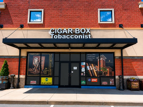 A modern tobacconist storefront featuring premium cigars, quality tobacco products, vape products, and smoking accessories. The well-maintained exterior and convenient entrance create an inviting destination for customers seeking trusted products and exceptional service.