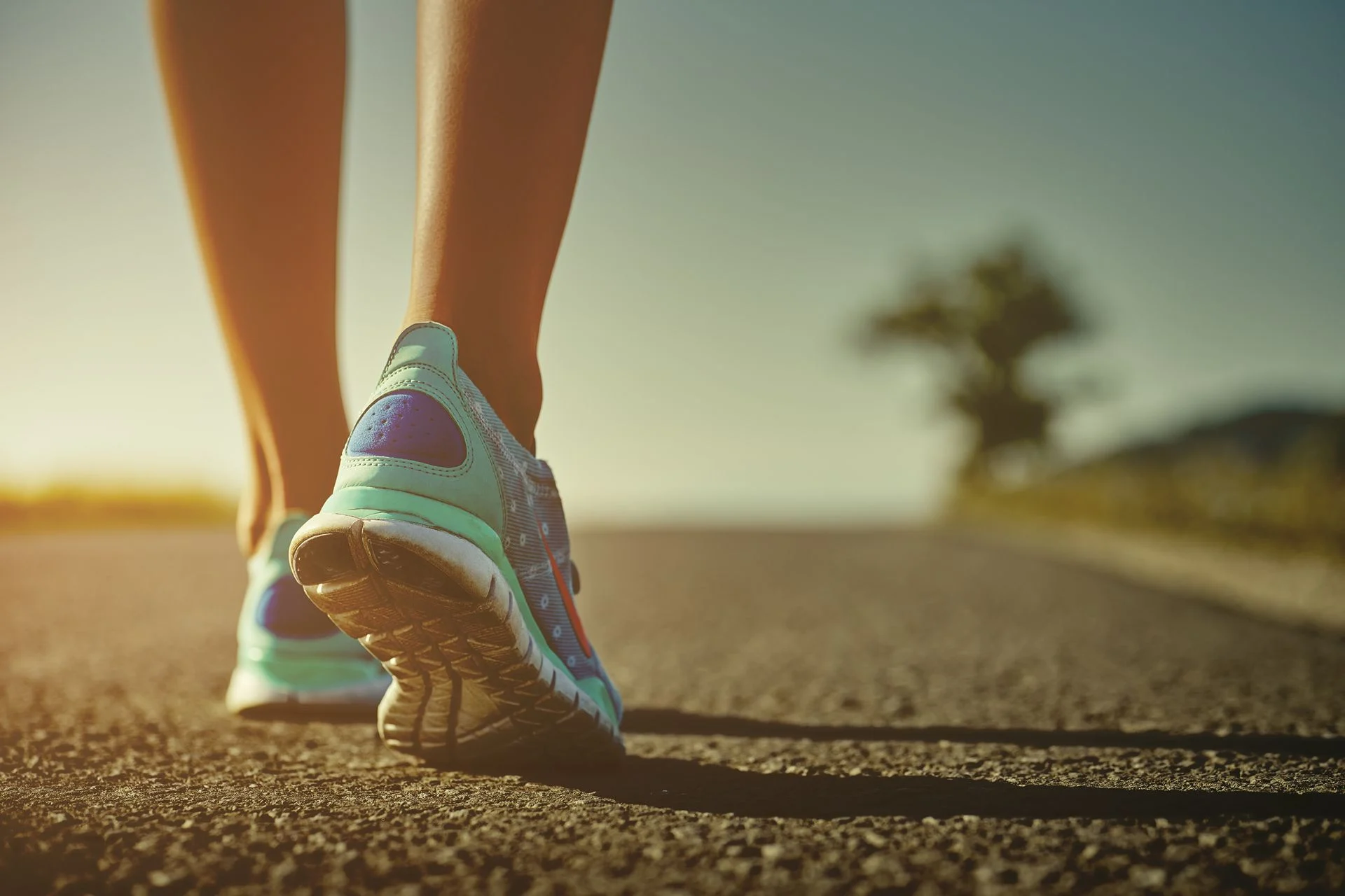 person walking on road wearing shoes with insoles for supination