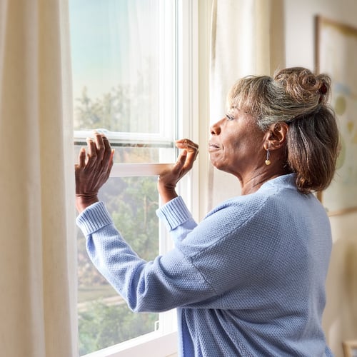 A woman opens her window.